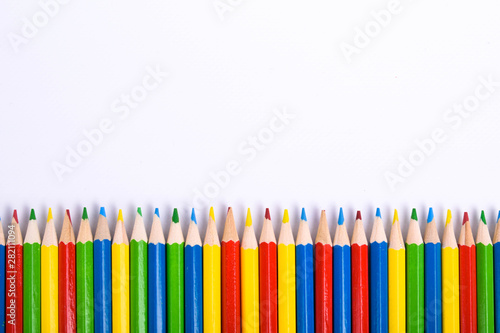 Many different colored pencils on a white background with a place for text and cory space .