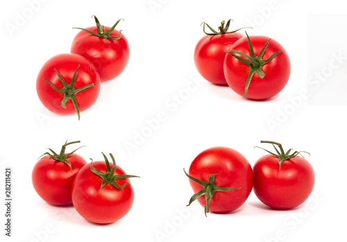 Red tomatoes on a white background. A group of tomatoes with herbs on a white background.