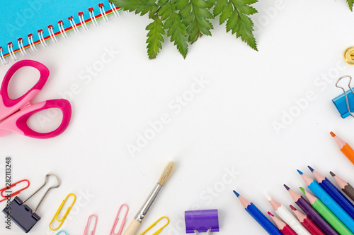 Education or back to school Concept. Top view of colorful school supplies with paints, brush, scissors, notepad, color pencils, pen cutter clips on white background. Flat lay. Copy space, frame 