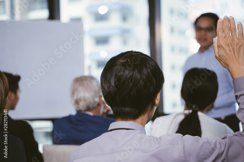 Raised up hands and arms of large group in seminar class room to agree with speaker at conference seminar meeting room