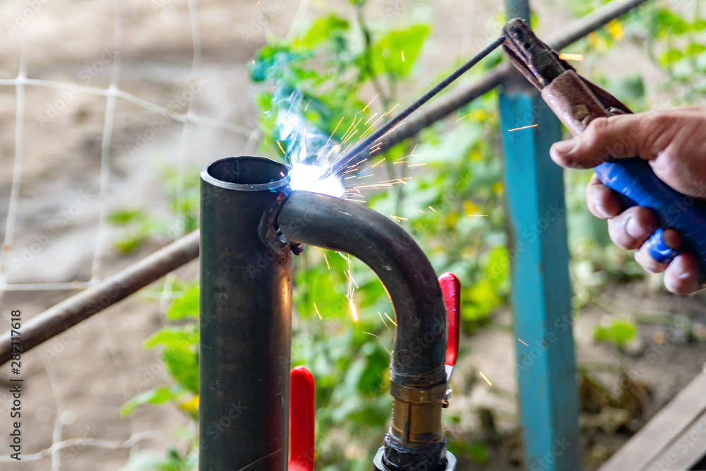 Worker cooks the heating pipe, welding joint. Preparing for winter heating. Worker cooks the heating pipe, welding joint. Preparing for winter heating.