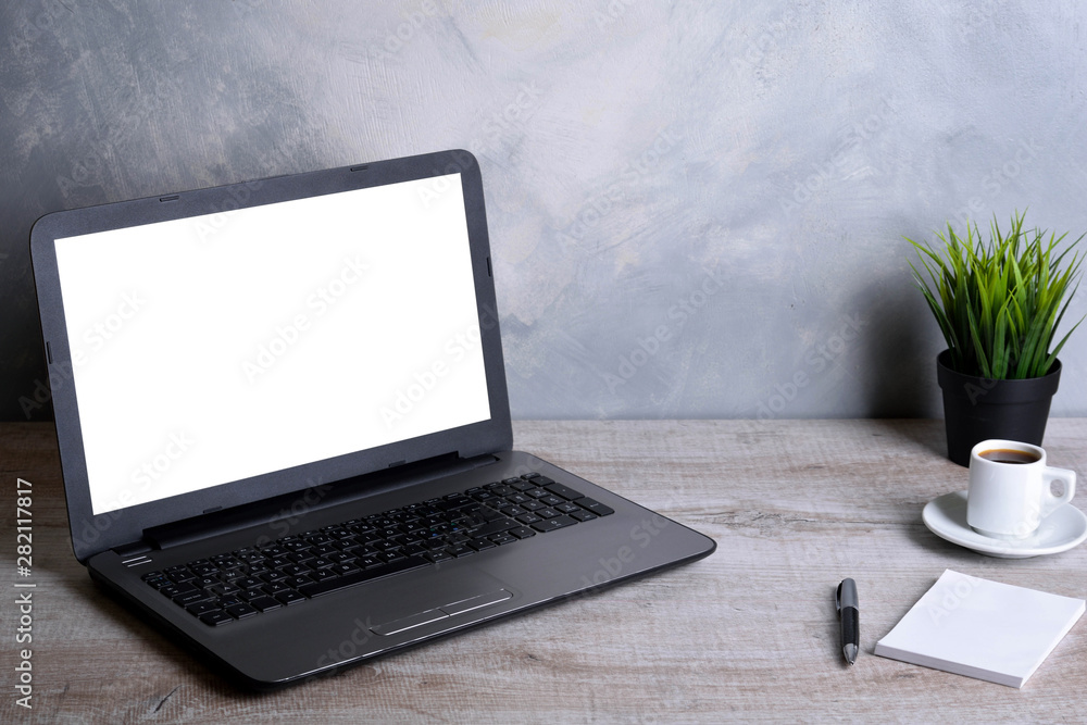 Fototapeta premium Laptop with blank screen for graphic display montage .Computer on wooden gray desk in office room. Mock up with plastic plant