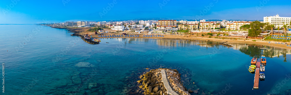 Cyprus. Protaras. The Paralimni harbour. Pernera. Kalamies beach top view. The jutting out into the sea beach forms the bays. St. Nicolas church Cyprus. Beach resort of Cyprus. Panorama with drone.