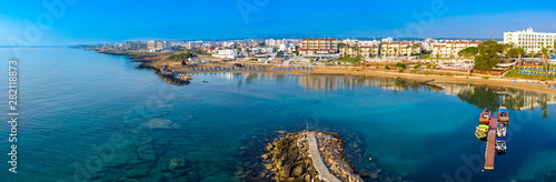 Cyprus. Protaras. The Paralimni harbour. Pernera. Kalamies beach top view. The jutting out into the sea beach forms the bays. St. Nicolas church Cyprus. Beach resort of Cyprus. Panorama with drone.