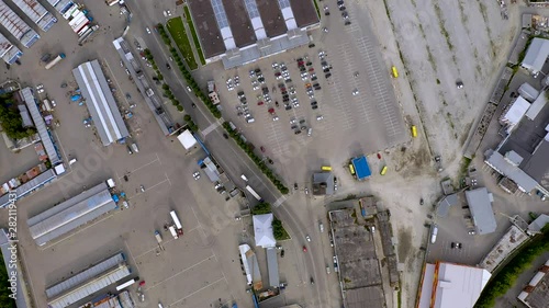 4k flying over carpark at shopping mall with empty places camera sliding up. Tracking aerial shot of cars moving parking routing outdoors urban abstract background. 4K footage from drone
