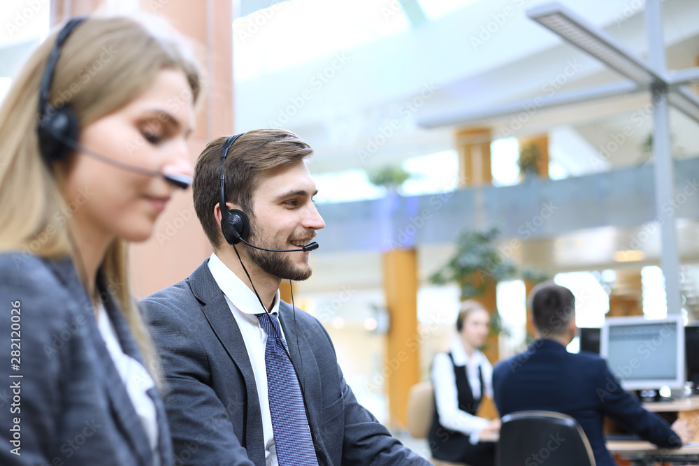 © ty - Portrait of call center worker accompanied by his team. Smiling customer support operator at work. © ty - Portrait of call center worker accompanied by his team. Smiling customer support operator at work.