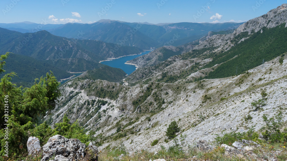 Amazing nature landscape in a National park with a Lake and green forest and desert grey mountains. Blue River and canyon. Mavrovo in Macedonia. Summer sunny day