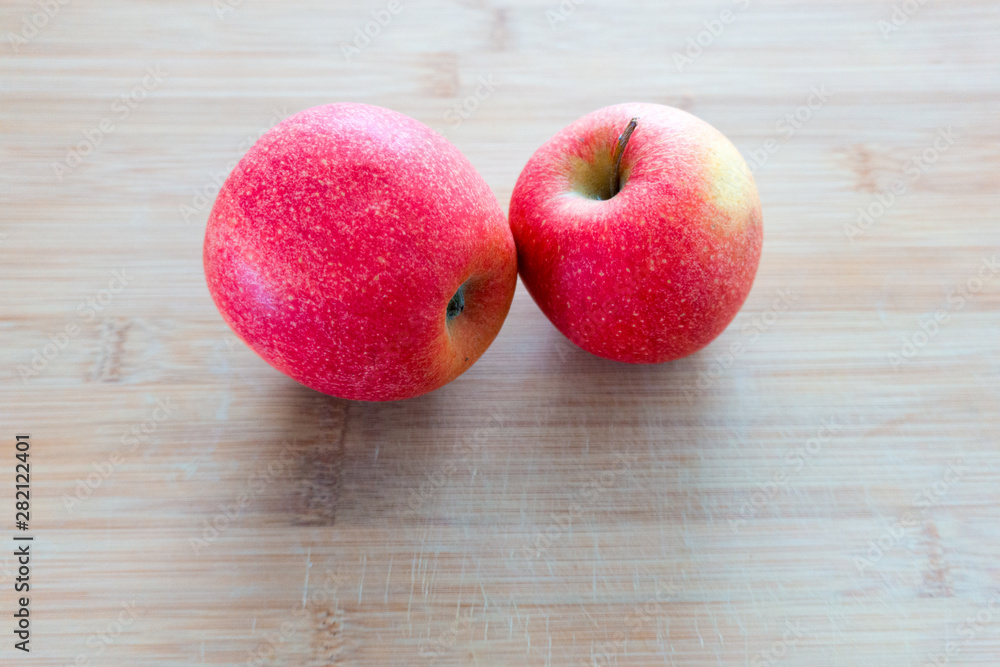 Zwei rote Äpfel auf einem Holzbrett Zwei rote Äpfel auf einem Holzbrett