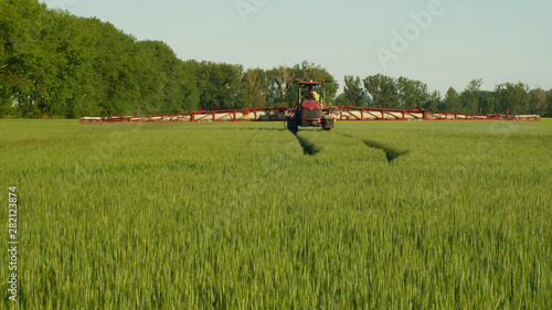 Special tractor for herbicide spraying against weeds, fields of barley Hordeum vulgare, chemical spray pesticides or rodenticide, the use of chemicals pollution, Europe