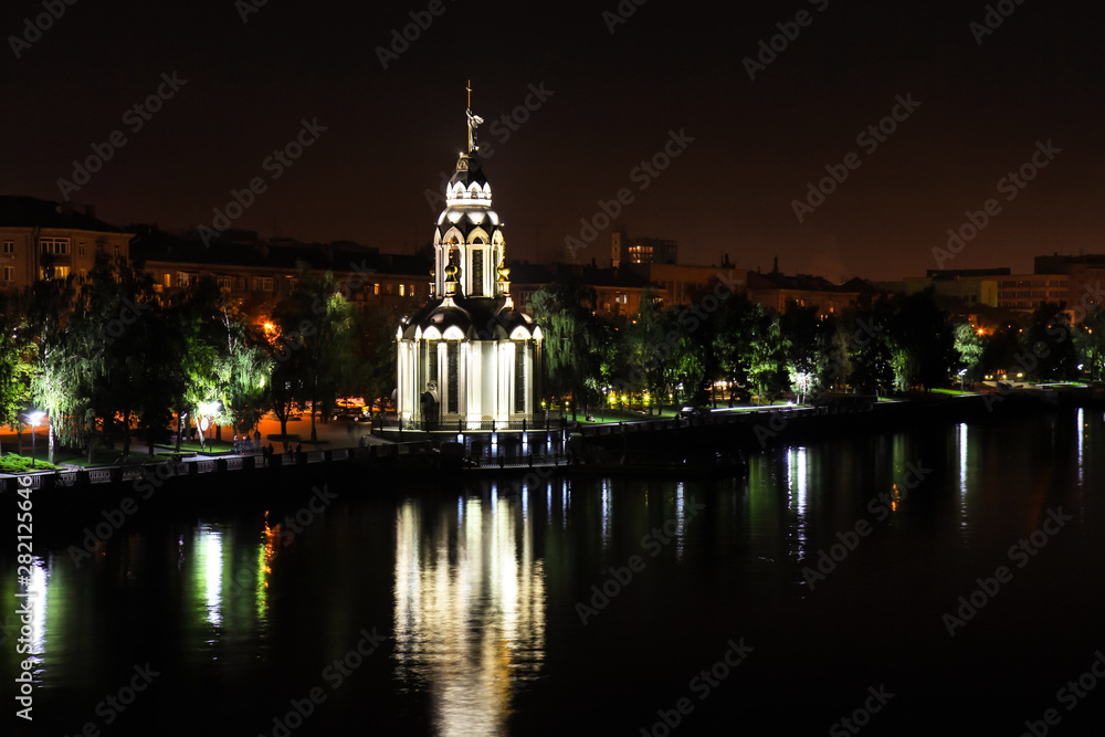 Night city landscape . Beautiful church with illuminating at night, lights reflected in the water. View of the Ukrainian city Dnepropetrovsk, Dnipro, Ukraine