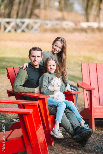 Father and cute daughters with dog outdoors