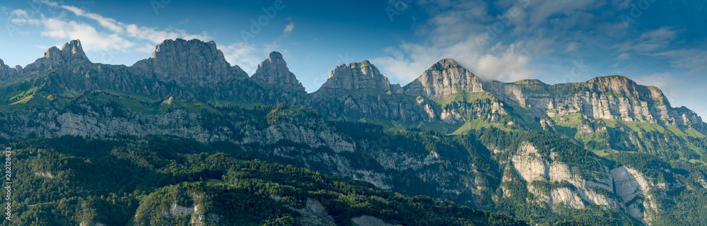 panorama mountain landscape in Switzerland with many mountain peaks in warm evening light