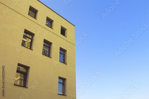 Yellow modern architecture building top corner on blue sky background