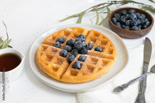 Belgian Waffle with Blueberries and Maple Syrup, Dusted with Powdered Sugar, Flay Lay on White Background, Copy Space