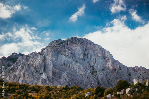 Russian mountains. Crimea. Summer mountains background. Forest and mountains in the sun on the background of a cloudy sky above the peninsula of Crimea. Sunny, bright, saturated raster photo