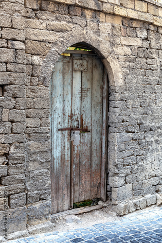 Wallpaper Mural An old fence of stone blocks, with a locked, arched wooden door Torontodigital.ca