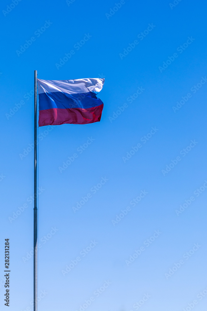 The government flag of Russia or Russian Federation on the sky background The government flag of Russia or Russian Federation on the sky background