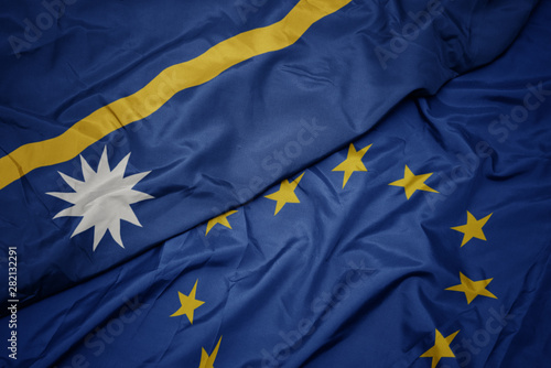 waving colorful flag of european union and flag of Nauru .