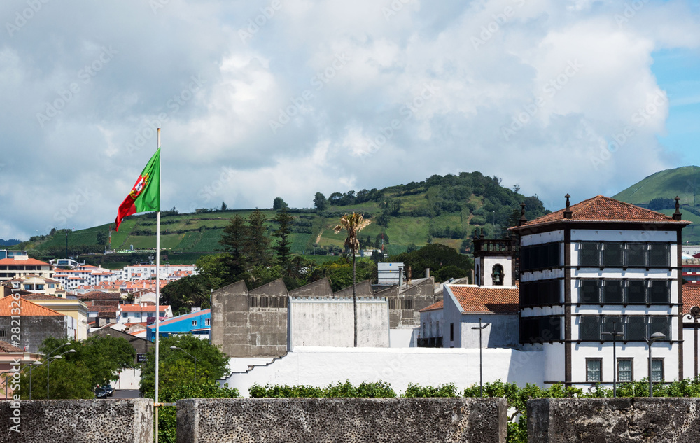 Beautiful view of the mountains, roofs of houses and streets of the city of Ponta Delgada, Portugal. Gray rain clouds over the city. Azores, the island of San Miguel. Beautiful view of the mountains, roofs of houses and streets of the city of Ponta Delgada, Portugal. Gray rain clouds over the city. Azores, the island of San Miguel.