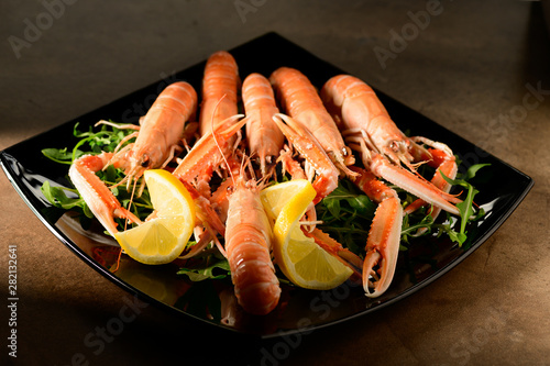 fresh grilled shrimps served on a plate with arugula or rocket and llemon photo