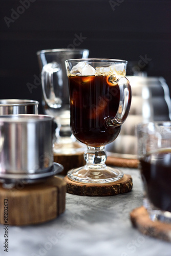 Making Vietnamese black drip ice coffee in irish mug on black background