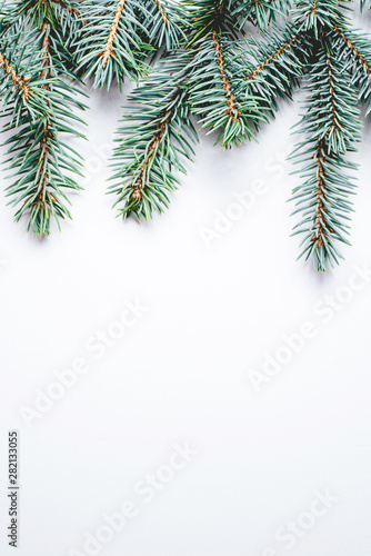 Fir branches on white wooden background. Christmas wallpaper. Flat lay, copy space. © Anna