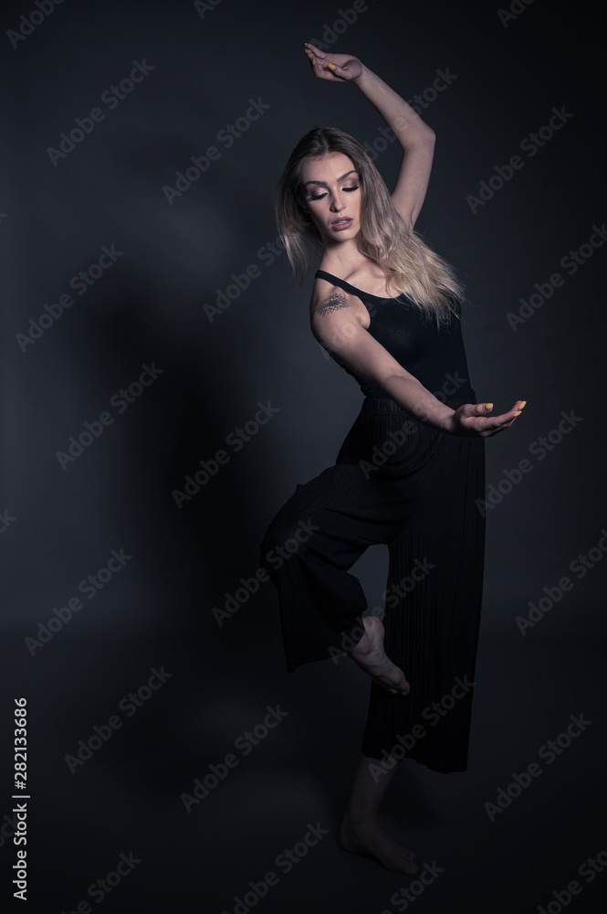 Beautiful dancer - young woman dance over dark gray background Beautiful dancer - young woman dance over dark gray background