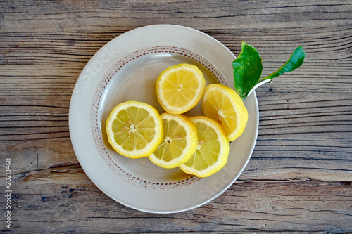 Zitrone geschnitten auf Teller auf Holztisch