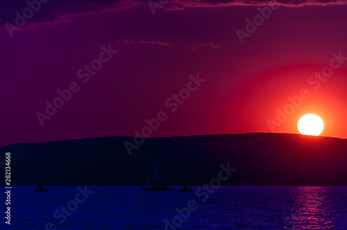 Synthwave themed colorful sunet over the Balaton lake photo