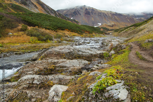 Beautiful waterfall in mountains, scenic autumn landscape in Kamchatka