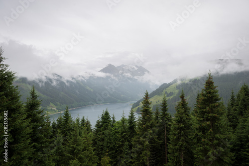 View of lake Speicher Durlassboden in Tirol, Austria with snowcapped mountains in the background