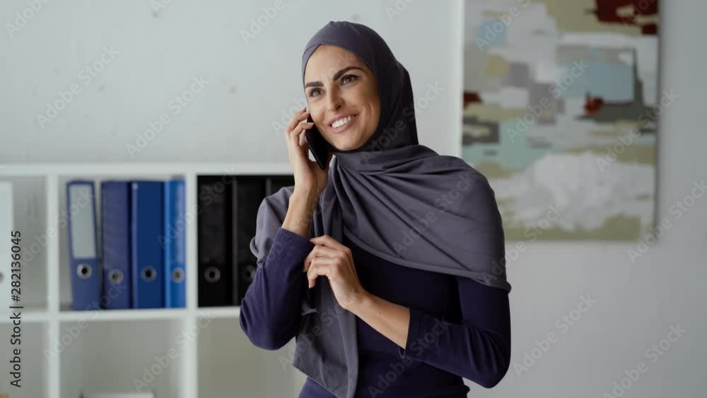 Muslim woman talking on the phone and receiving a second incoming call. Businesswoman negotiating. Muslim woman talking on the phone and receiving a second incoming call. Businesswoman negotiating.