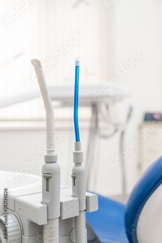 Close-up dentist saliva ejector. Dental work in clinic. Operation, tooth replacement. Medicine, health, stomatology concept. Office where dentist conducts inspection and concludes.