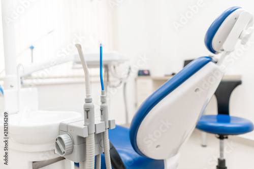Close-up dentist saliva ejector. Dental work in clinic. Operation  tooth replacement. Medicine  health  stomatology concept. Office where dentist conducts inspection and concludes.