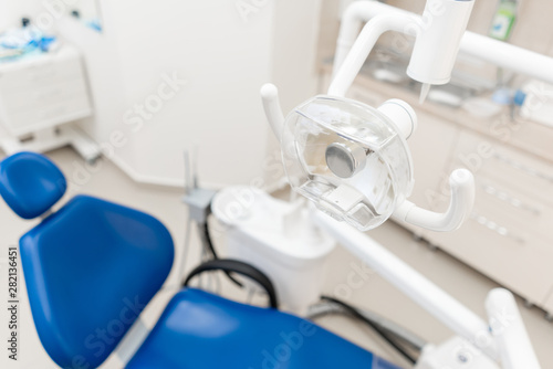 Close-up dentist lamp. Dental work in clinic. Operation  tooth replacement. Medicine  health  stomatology concept. Office where dentist conducts inspection and concludes.