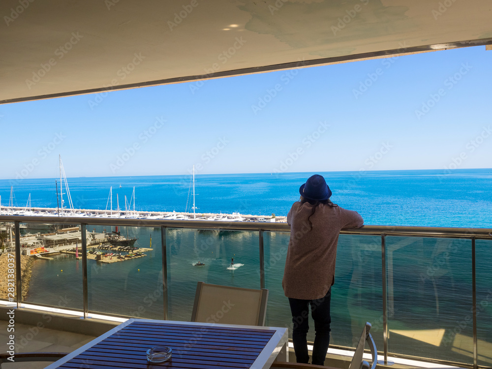 Mujer mirando el mar desde el hotel