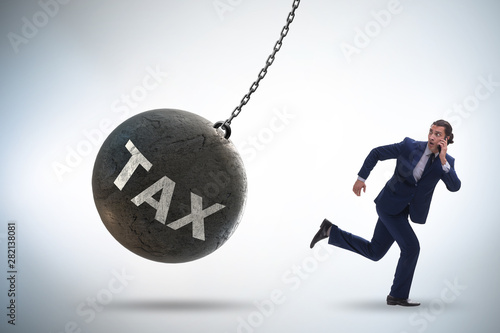 Businessman running away from high taxes photo