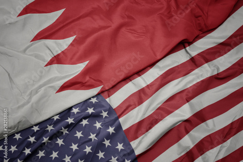 waving colorful flag of united states of america and national flag of bahrain.