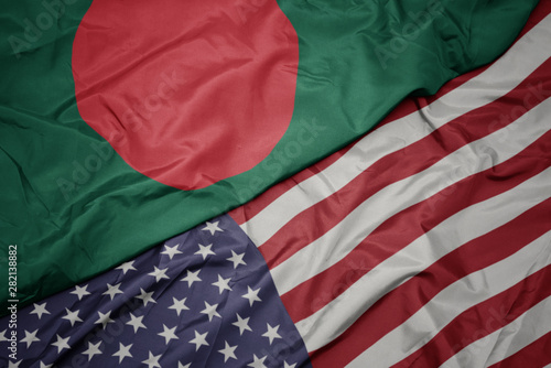 waving colorful flag of united states of america and national flag of bangladesh.