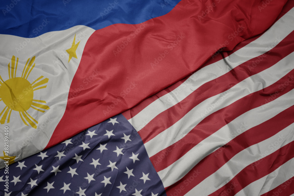 Obraz premium waving colorful flag of united states of america and national flag of philippines.