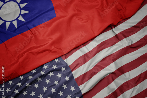 waving colorful flag of united states of america and national flag of taiwan.