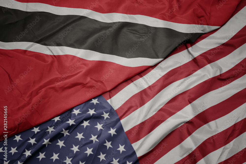 Obraz premium waving colorful flag of united states of america and national flag of trinidad and tobago.