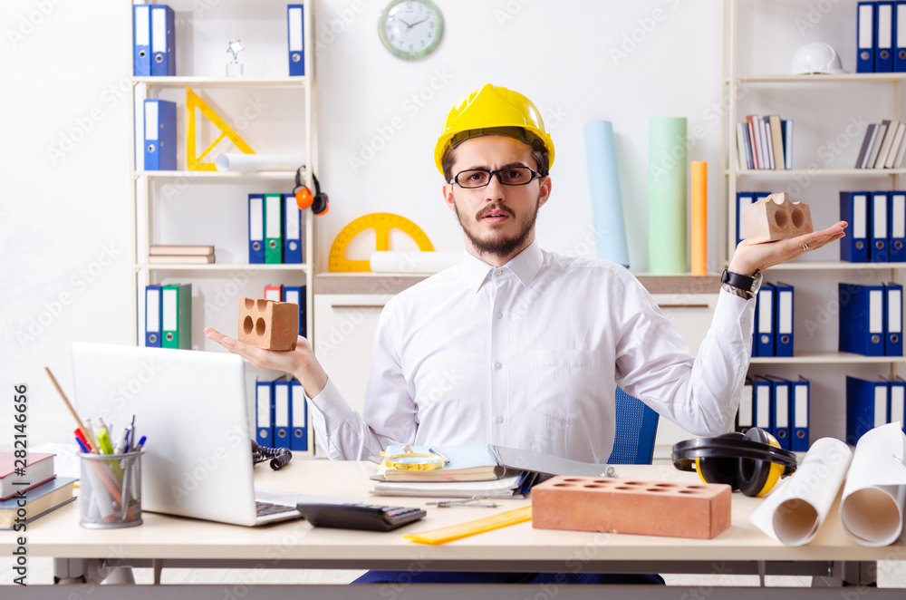 Young male architect working in the office Young male architect working in the office