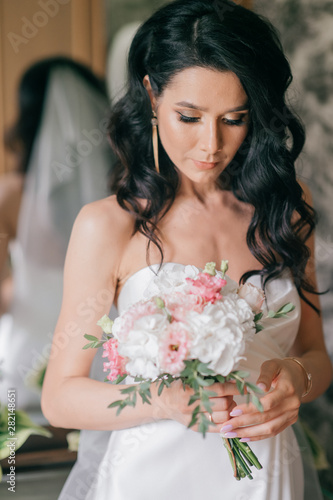 Beautiful young bride in white wedding dress indoor portrait