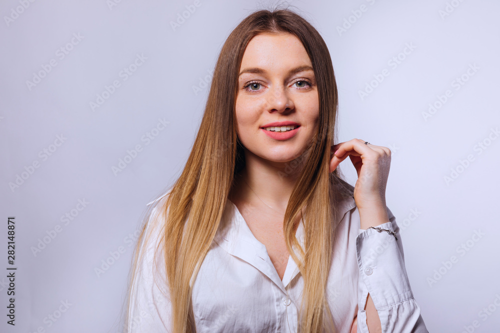 young woman wearing formal white blouse and posing on the backg young woman wearing formal white blouse and posing on the backg