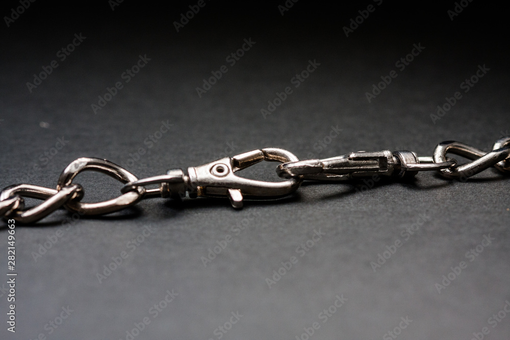 Fototapeta premium Chromed silver chains on a black background. Long and careful. Jewelry.