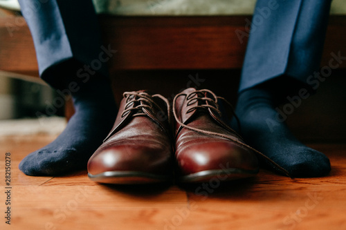 Groom getting ready in the morning. Groom closeup legs and shoes.