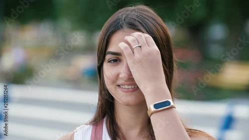 Cheery brunette girl standing and smiling on Dnipro embankment in slo-mo  photo