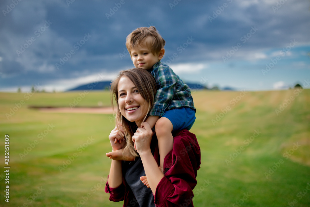 mother have a fun with a son on a meadow in mountains mother have a fun with a son on a meadow in mountains
