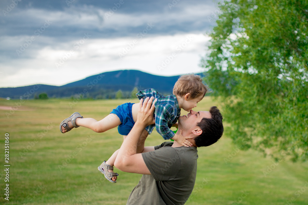 Fototapeta Ojciec i mały chłopiec bawią się w górach